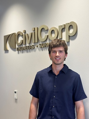 Cy Richter smiles in front of the CivilCorp logo at the headquarters