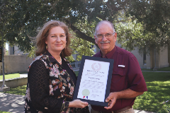 Dr Jennifer Kent and Lawrence Wick hold a framed recognition from the governor