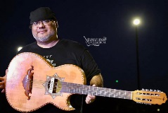Isaac De Los Santos poses with his guitar on stage