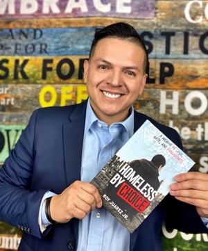 Roy Juarez Jr holds a copy of his book