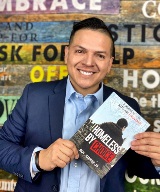 Roy Juarez Jr holds a copy of his book