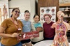 Tutor Alex and 3 nursing students hold a #PirateProud sign in the learning lab