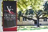 Victoria College maroon and black banner outdoors on a sunny day